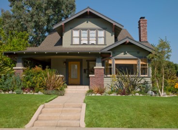 a large brick building with grass in front of a house